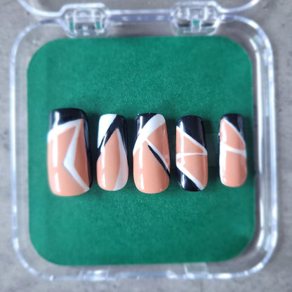 Set of nail art designs in a clear case on a green background