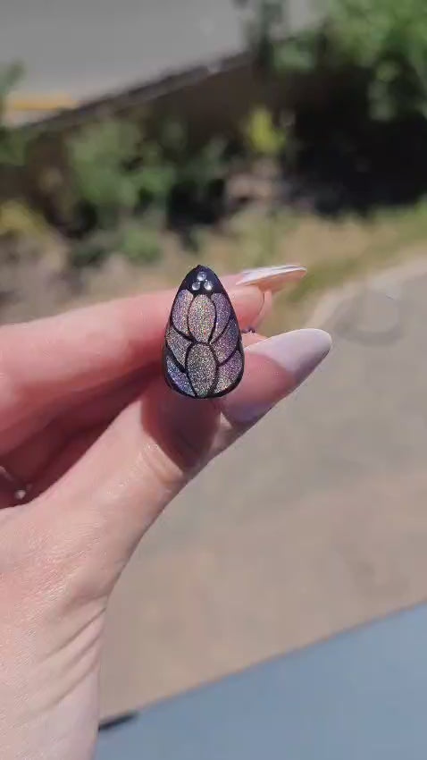 video of butterfly design nail reflecting in sunlight 